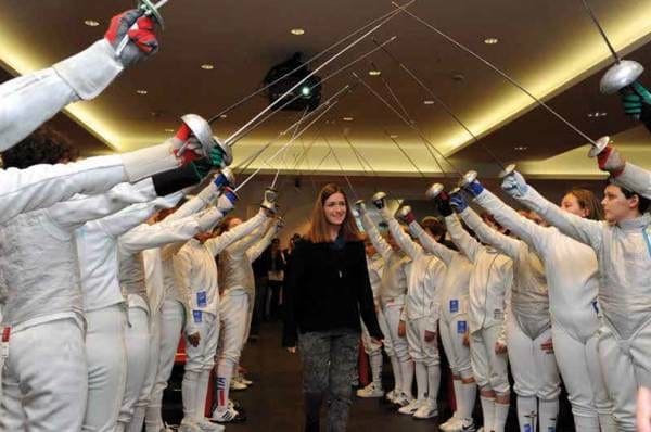Martina Caironi passa sotto un arco di spade e fioretti alzati da giovani schermidori al Premio Mangiarotti 2013